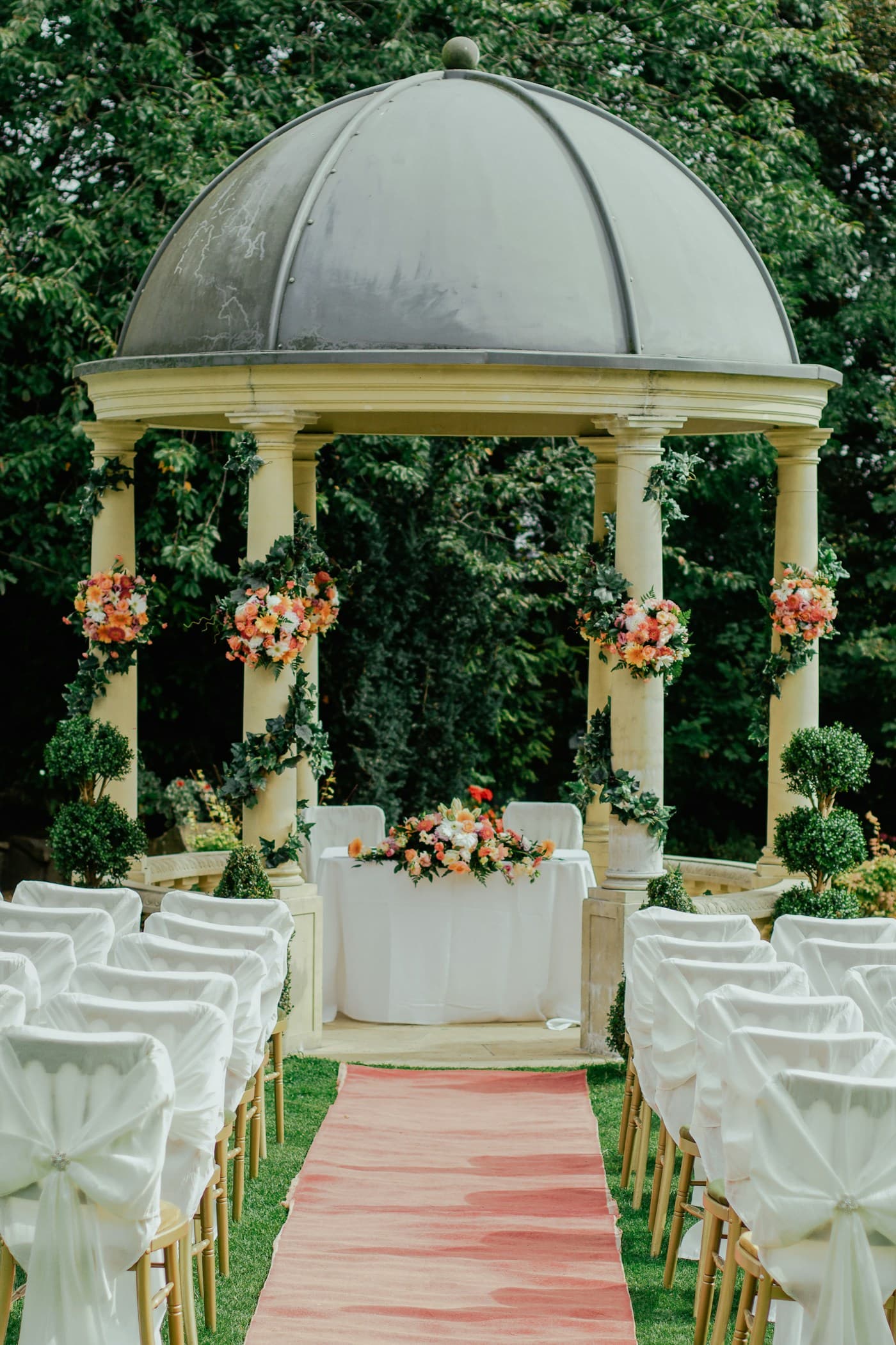 Elegant outdoor wedding ceremony with sculptural floral arrangements